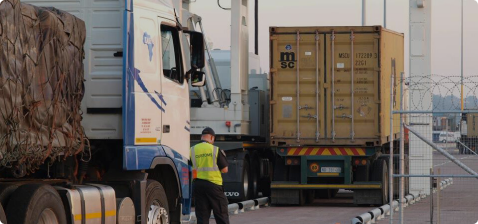 Белый грузовик Mercedes-Benz Actros 2532 проходит сканирование на таможенном пункте ФТС России, сотрудник таможни в форме стоит рядом с мобильной сканирующей установкой Techno